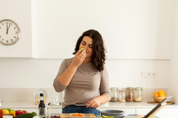Woman smelling lime while cooking at home