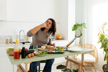 Woman eating at kitchen