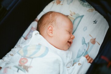  a newborn baby sleeping and smiling
