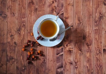 Wooden floor rosehip tea and rosehip herb.
