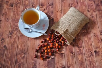 Rosehip tea. Rosehip in a pouch. Wooden floor.