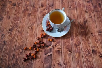 Wooden floor rosehip tea and rosehip herb.
