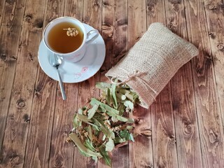 Linden tea. Linden plant in a pouch. Wooden floor.