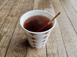 Drinking tea in a cardboard cup.