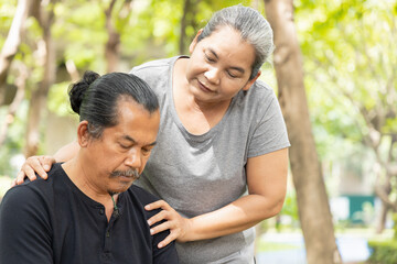 Fototapeta premium Old senior woman hugging, taking care of her husband suffering from Alzheimer disease