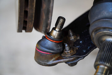 Left driveshaft of front axle with disc brake and ball joint, service center is replacing the driveshaft in the garage.