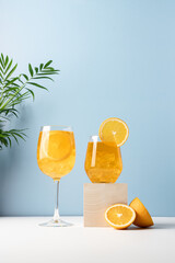 Orange drink with ice in glass on blue background. Refreshing tropical summer fruit lemonade or...
