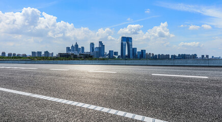 Asphalt road and city skyline with modern building scenery in Suzhou, Jiangsu Province, China.