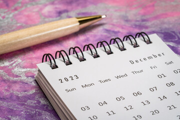 December 2023 - closeup of a small desktop calendar with a pen, time and business concept