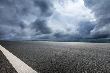 Asphalt road and sky black cloud background