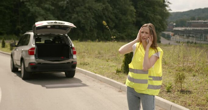 LYoung woman in vest calling for roadside service