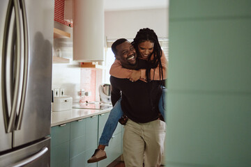 Black couple, piggyback and love while together in home kitchen with care and happiness in a marriage. Happy young man and laughing woman playing fun game while to bond in their house or apartment - Powered by Adobe