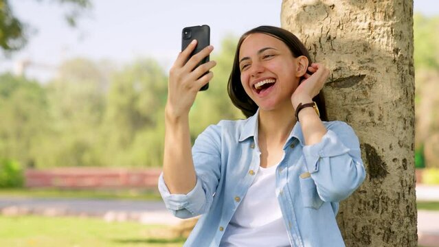 Happy Indian girl taking and clicking selfies and photographs of herself
