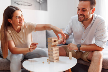 Couple having fun playing balance block stacking game