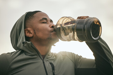 Fitness, health or black man drinking water after training, exercise or workout for body hydration....