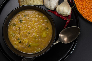 Portion of lentil soup on a black background. traditional cooking