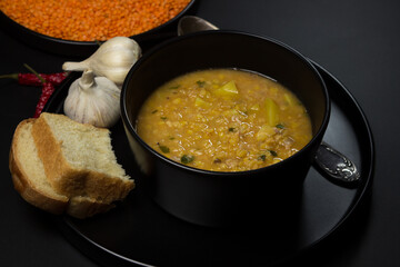 Portion of lentil soup on a black background. traditional cooking