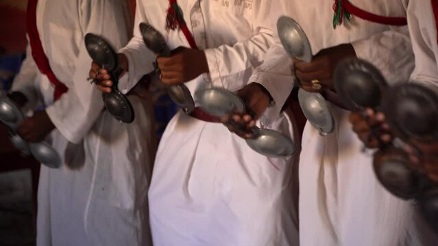 Hands moving instruments during a tribe ritual dance in Morocco by African tribe