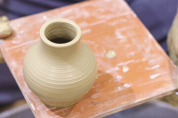 Pottery artist showing clay vase in ceramic studio. Creative handmade craft.