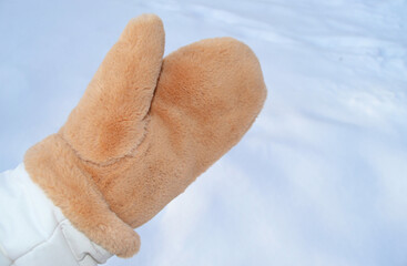 Warm soft mittens against the background of white snow