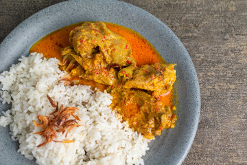 tasty chicken curry food with steam rice and fried shallot on top on a plate