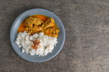 tasty chicken curry food with steam rice and fried shallot on top on a plate