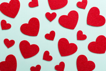 Felt hearts on color background, top view