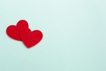 Felt hearts on color background, top view