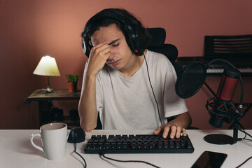 young gamer boy with headache touching his face out of frustration or because he has eyestrain from...