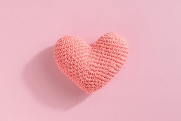 Crocheted amigurumi pink heart on a pink background. Valentine's day banner