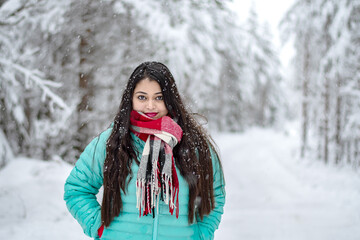  Portrait of a beautiful woman dressed with colourful jacket. A beautiful woman in coloured jacket walking through the Magical winter forest.