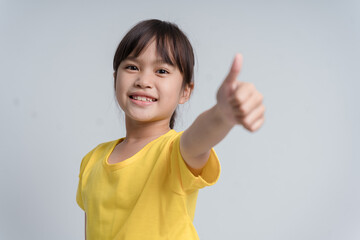 Photo of young little girl happy positive smile show thumb-up like fine recommend ad isolated over white color background