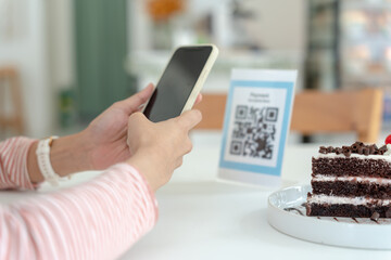 Woman use smartphone to scan QR code to pay in cafe restaurant with a digital payment without cash. Choose menu and order accumulate discount. E wallet, technology, pay online, credit card, bank app.