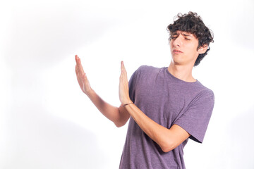 young man rejecting something, on the side of the copy space. Isolated on white background