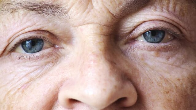 Gray tired and sick eyes of an old woman whose face is wrinkled. Ophthalmology. The study of vision. The need for medical intervention