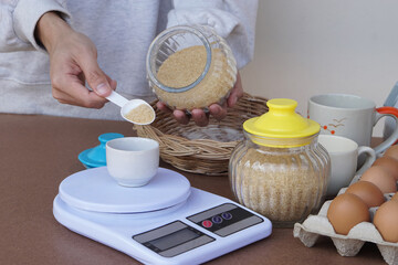 Closeup hand scales sugar for cooking, prepares eggs and other  food ingredients for make cookies. Concept, cooking , bakery. Love cooking lifestyle. Pastime activity. Kitchen   