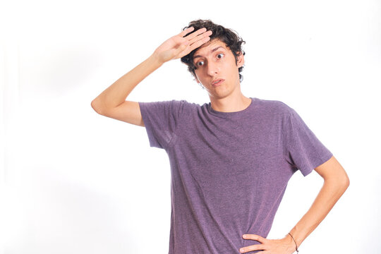 Young Hispanic man making phew gesture. Isolated on white background.