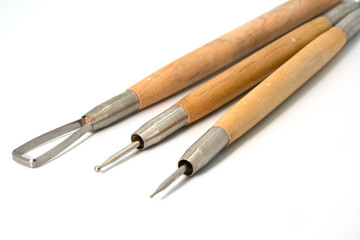 Tools for working with polymer clay on a white background