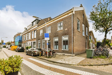 an old brick building in the netherlands, with bicycles parked on the street next to it and two...