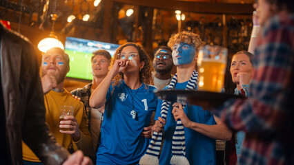 Group of Multicultural Friends Watching a Live Soccer Match in a Sports Bar. Excited Fans with...