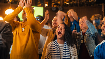 Group of Diverse Soccer Fans Cheering Their Team During a Football Game Live Broadcast in a Sports Pub. Anxious Crowd Saddened and Angry When Competitor Player Scores a Decisive Goal.