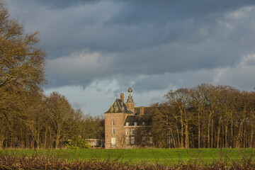 Fototapeta premium dark clouds over the medieval castle of Laag Keppel near river Oude IJssel in winter