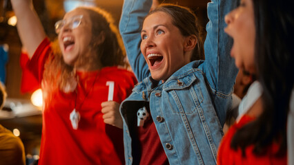 Three Female Friends Watching a Live Soccer Match on TV in a Sports Bar. Happy Girls Cheering and...