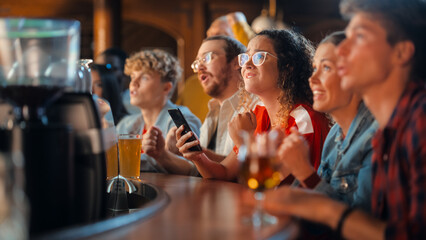 Portrait of an Anxious Multiethnic Female in Red Jersey Using a Smartphone, Nervous About the Sports Bet on Her Favorite Soccer Team. Young Woman Full of Joy When Football Team Scores a Goal.