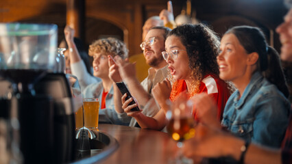 Excited Female Holding a Smartphone, Sitting at a Bar Stand. Nervous About the Sports Bet She Put on a Her Favorite Soccer Team. Joyful When Football Team Scores a Goal and She Wins the Prize.