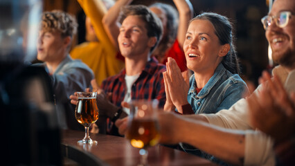 Portrait of a Beautiful Female Sitting at a Pub Counter with Group of Diverse Friends, Watching and Cheering for a Live Soccer Match. Supportive Fans Cheering, Applauding, Shouting and Drinking Beer.