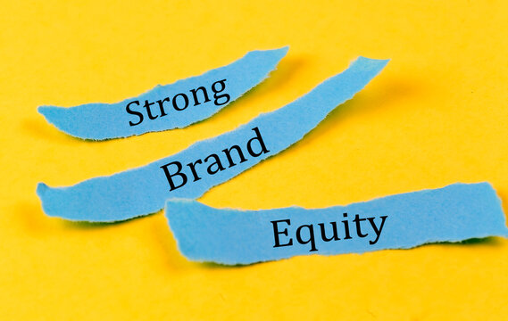 STRONG BRAND EQUITY text on a blue pieces of paper on yellow background, business concept