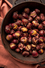 Roasted chestnuts, in an iron pan, wooden table, top view, no people, rustic style,