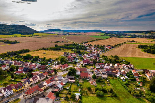 Aer ial view of a German village surrounded by meadows, farmland and forest in Germany.