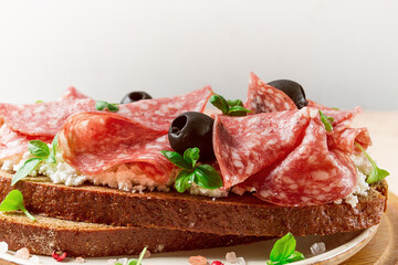 Sandwich , grain bread, with cream cheese and salami, black olives, micro-greens, top view, close-up, no people, Breakfast,